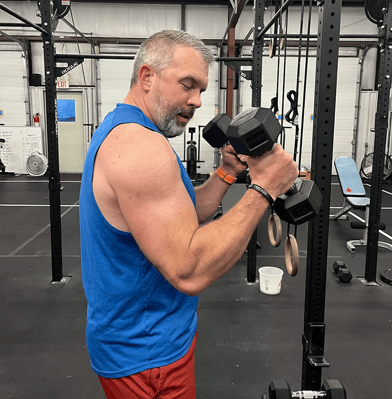 man lifting dumbbells at RPE Strength and Fitness